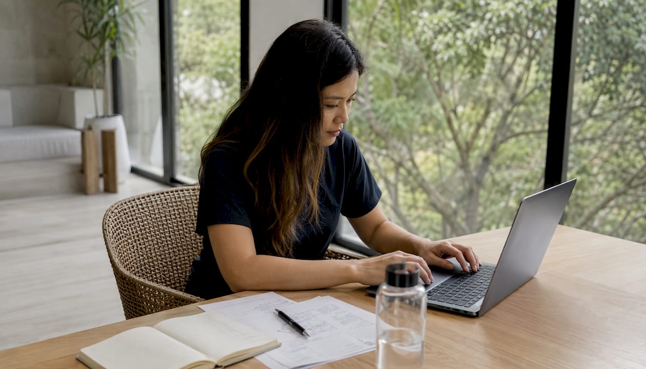 Une femme appliquée travaille depuis son bureau à la maison, plongée dans ses tâches.