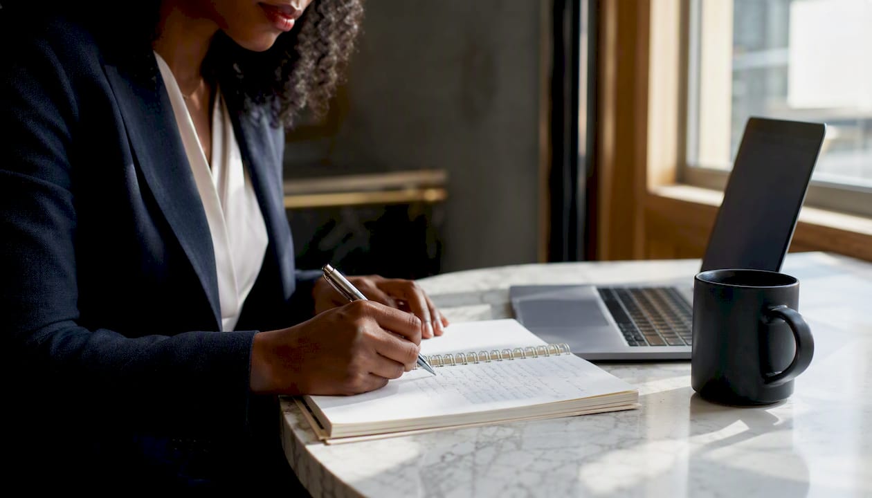 Des mains prennent des notes sur les critères d’évaluation et les processus d’automatisation.