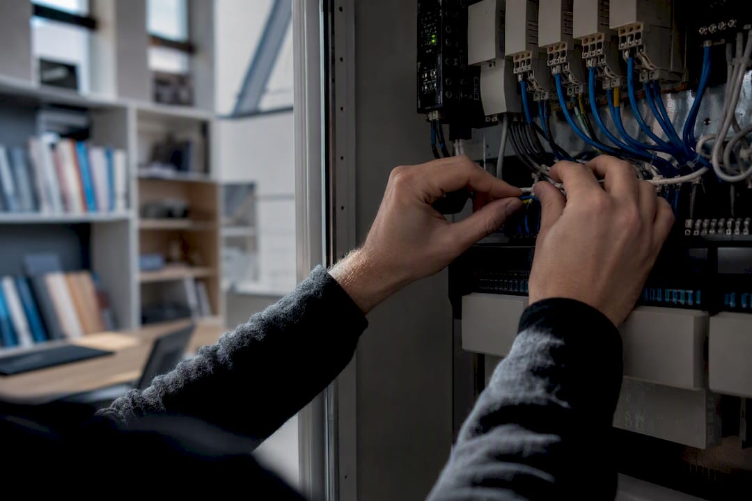 Mains câblant un panneau de contrôle automatisé pour le suivi des indicateurs clés