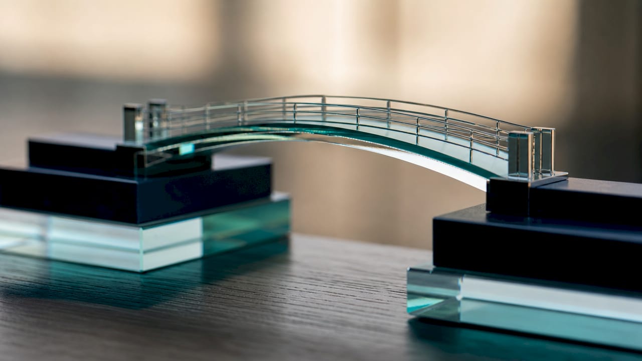 Close-up of sleek model bridge connecting platforms in sunlight