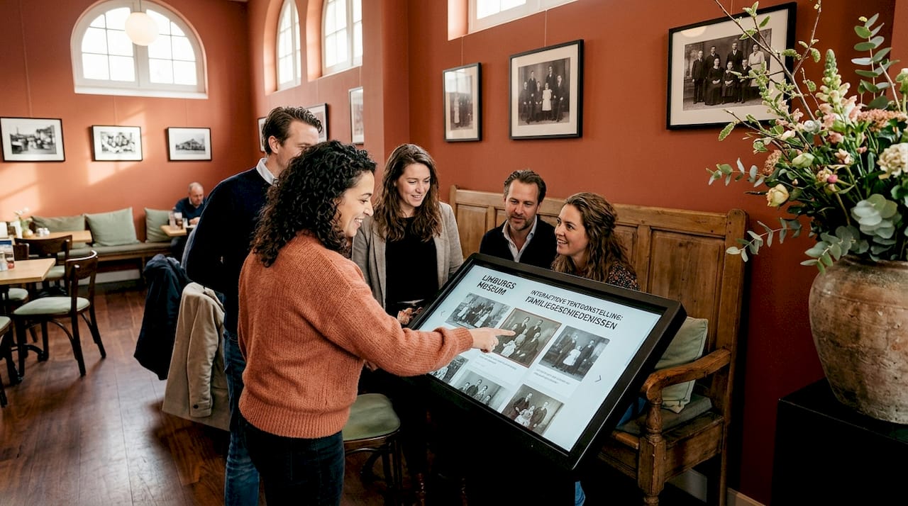 Een groep mensen verdiept zich samen in een interactieve tentoonstelling in het museum.