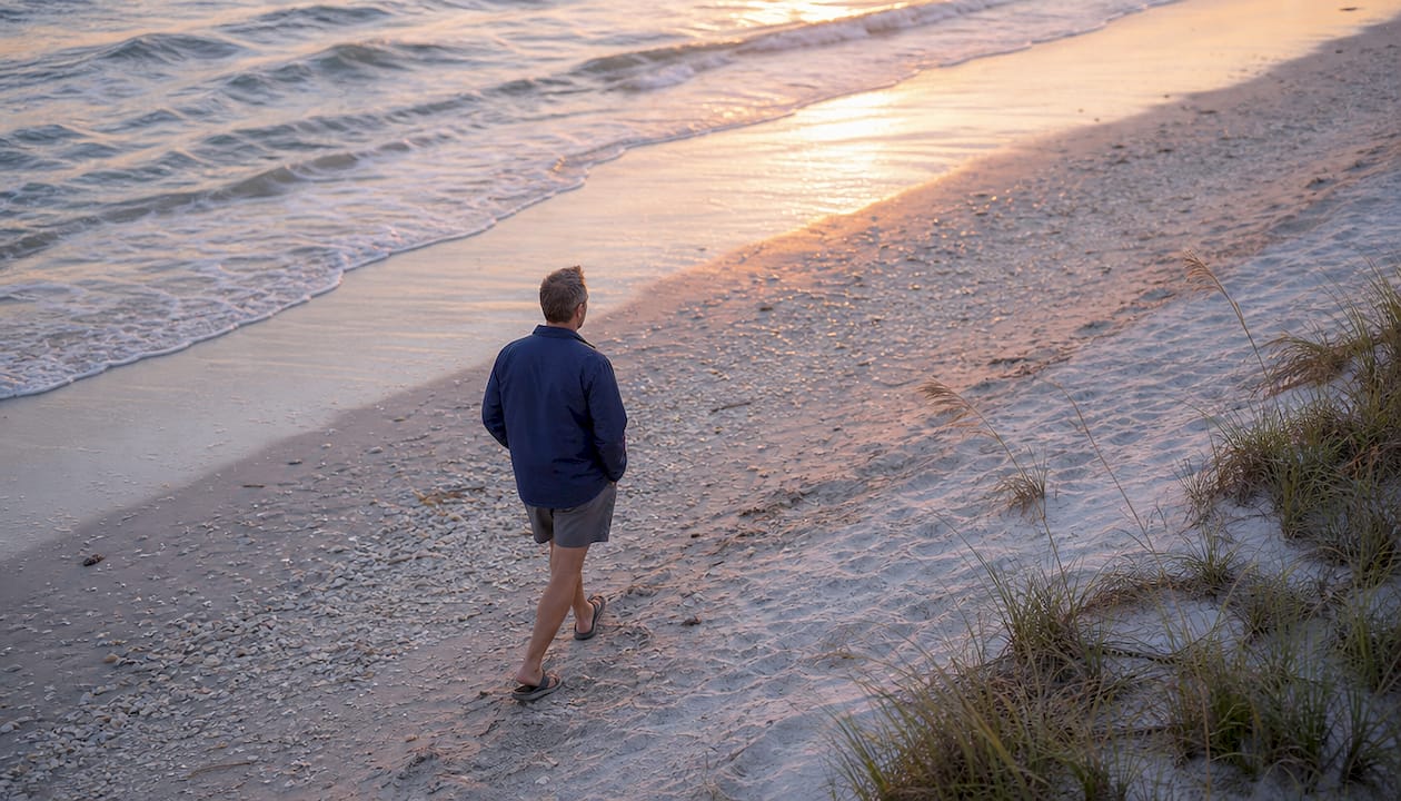 Man walking on beach at sunset golden hour