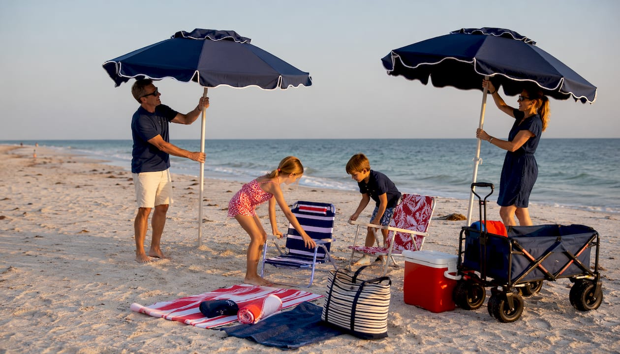 Family setting up rented beach gear on beach