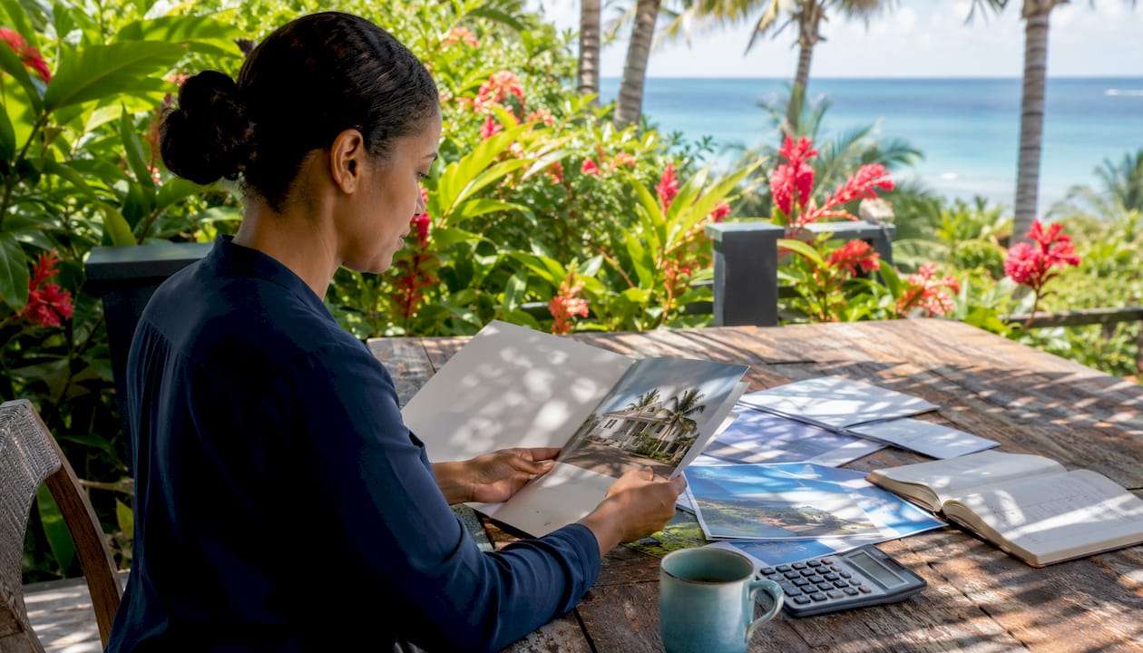 Hands sorting vacation home purchase documents