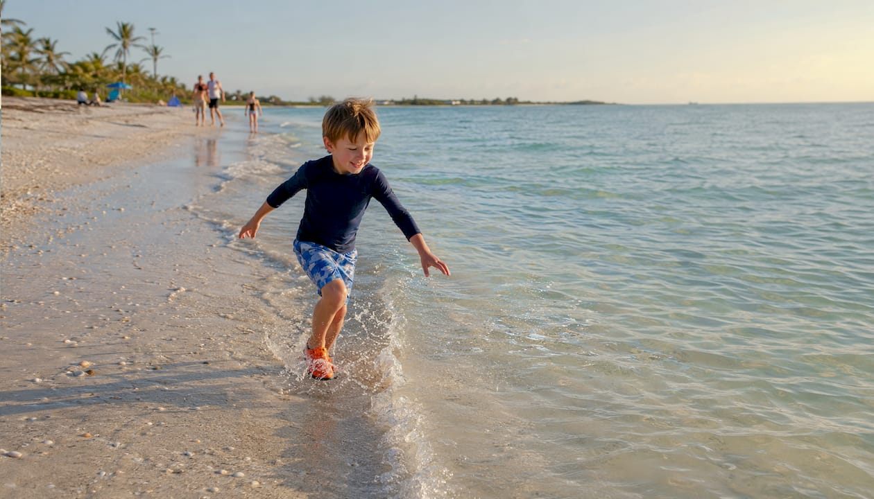 Child performing stingray shuffle in beach water