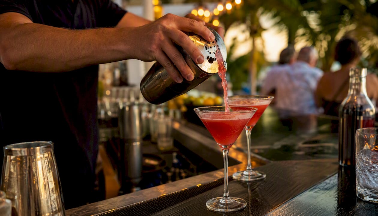 Bartender pouring tropical cocktail at happy hour