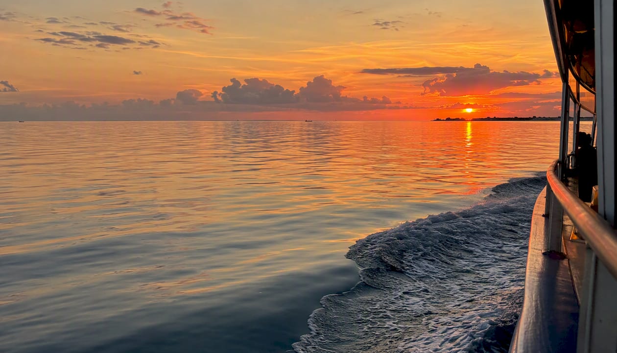 Sunset over open Gulf water from a cruise boat deck