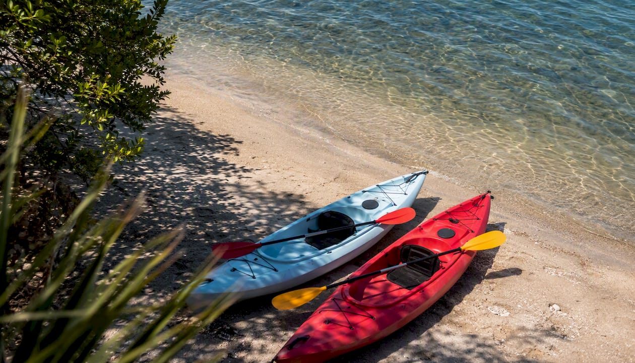 Kayaks resting near sandy shoreline at Tween Waters Inn