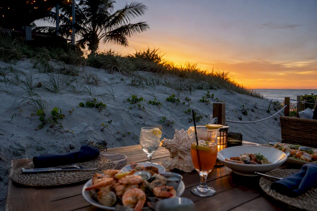 Outdoor restaurant patio with dune blocking sunset view