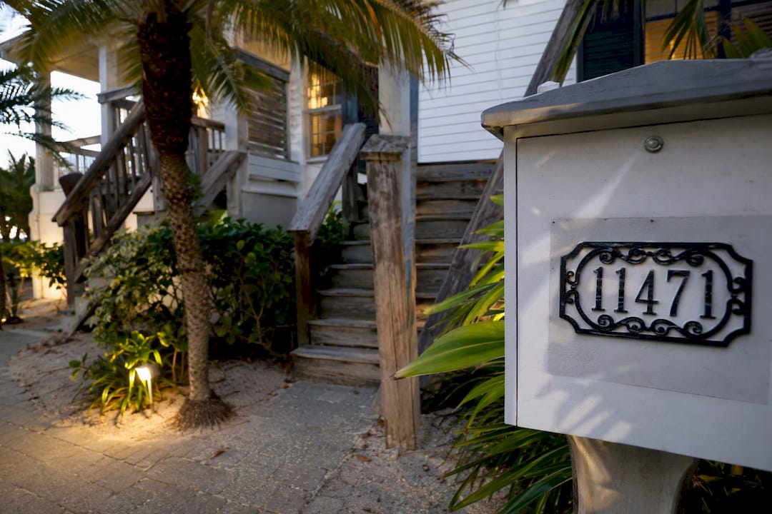 Vacation home porch with house number and plants