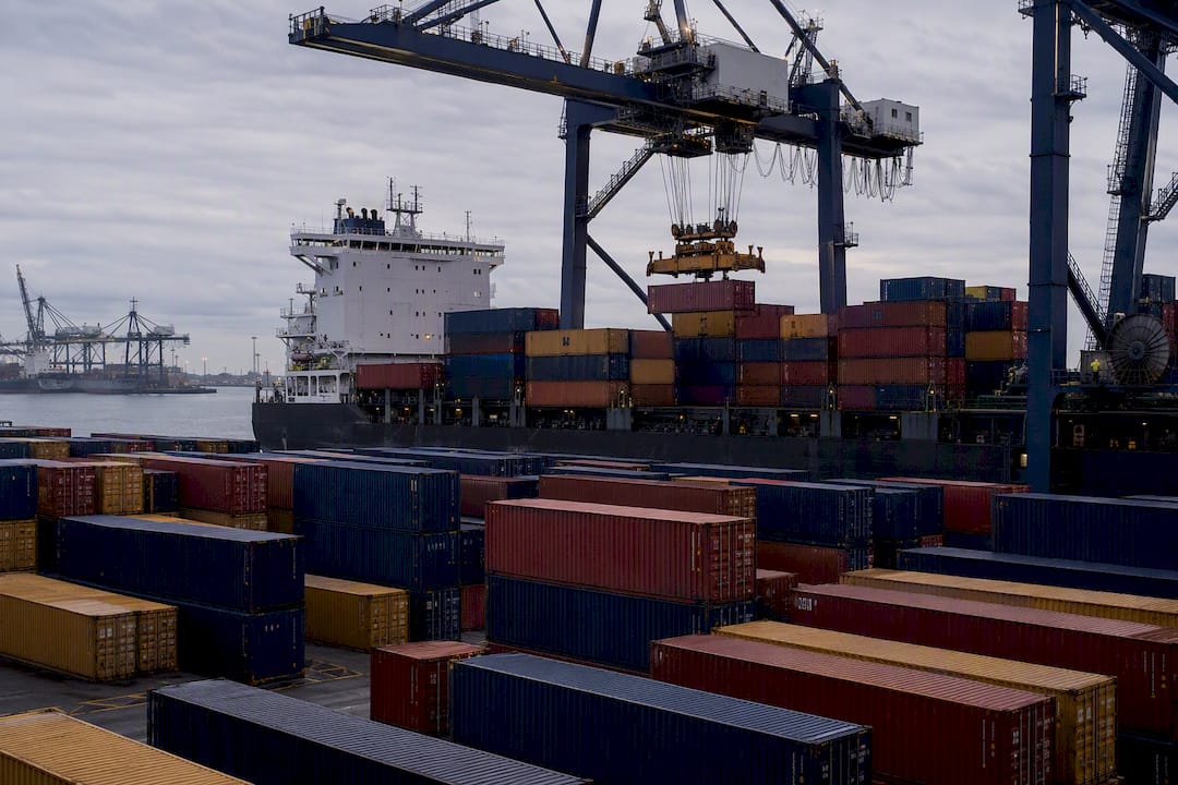 Shipping containers at busy port at sunset