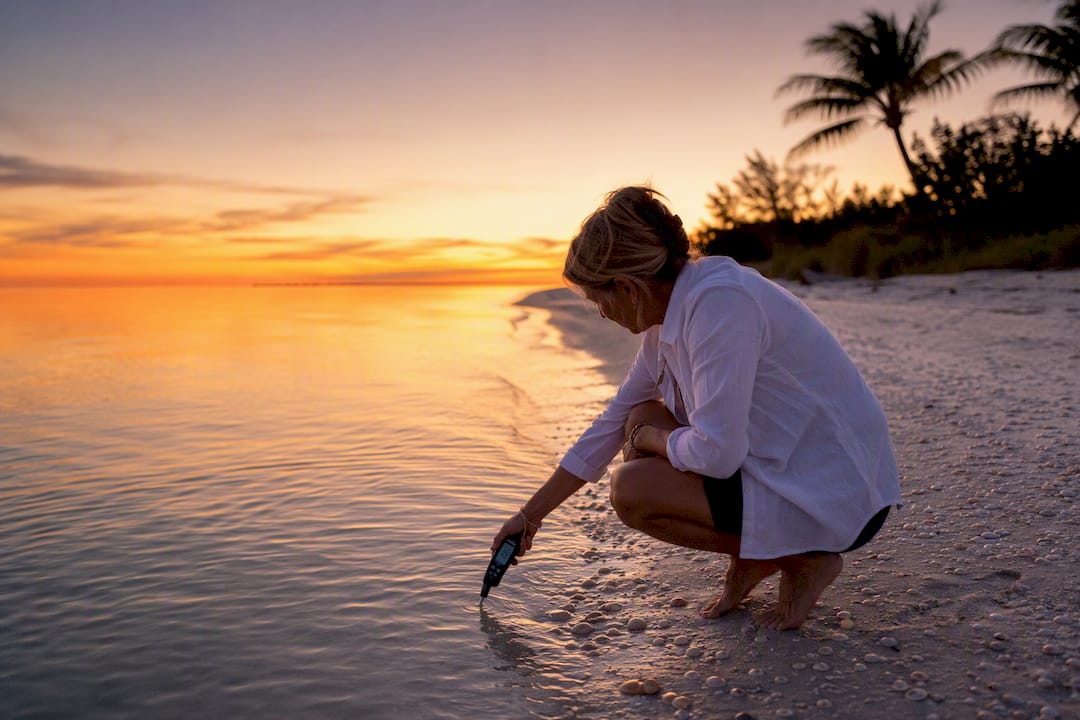 Hand holding water thermometer in gulf water