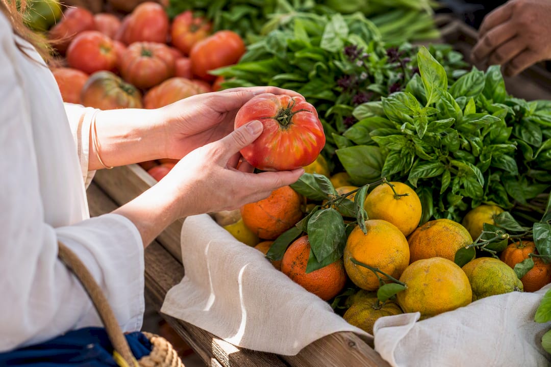 Shopper examining fresh uneven market produce