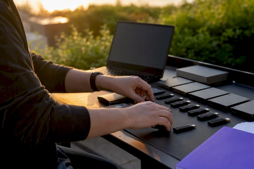 Hands handling USB drives for evidence