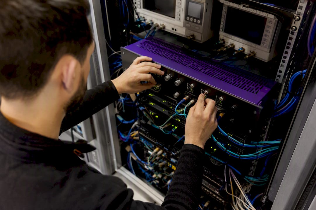 Hands adjusting low-latency trading device cables