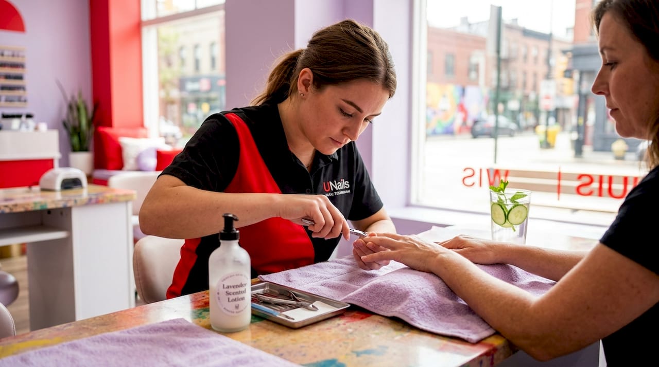 Nail technician caring for client hands