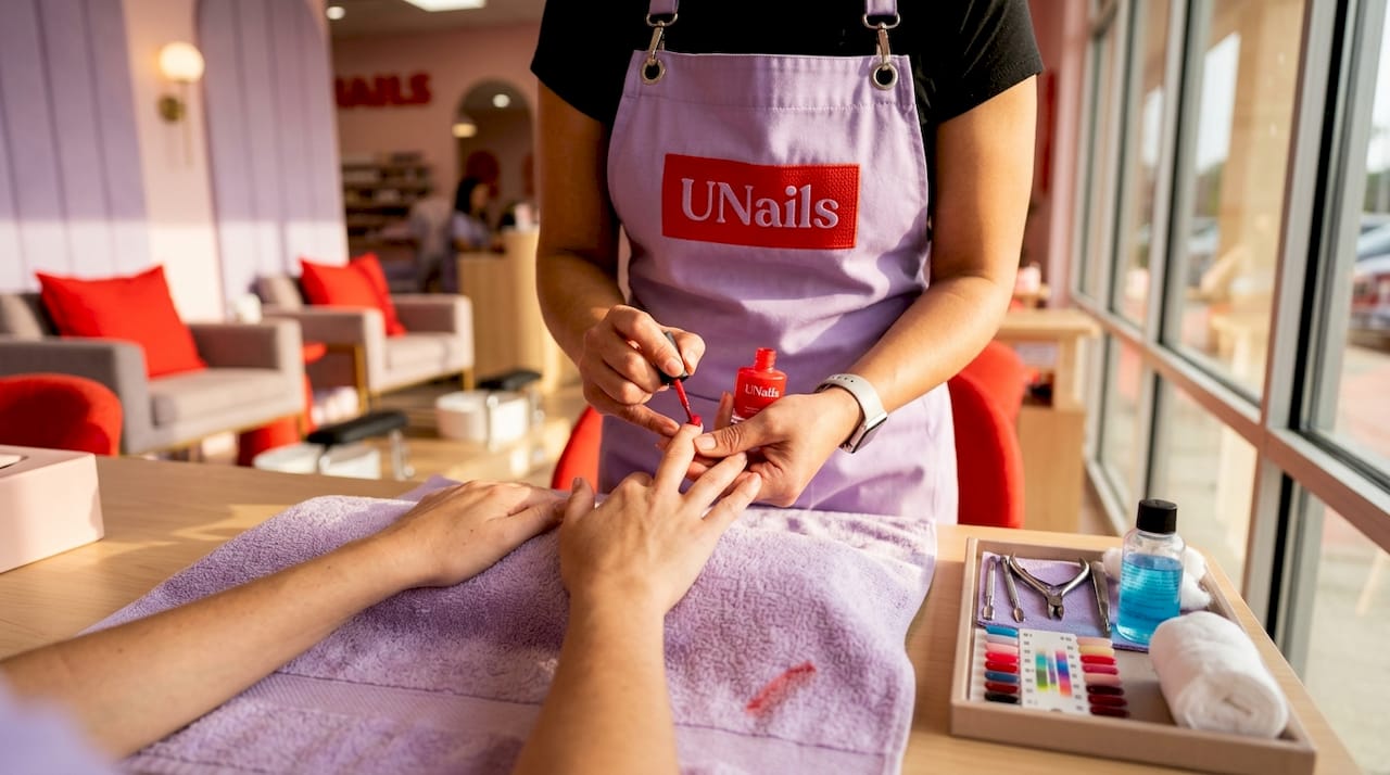 Nail technician applying polish to client’s nails