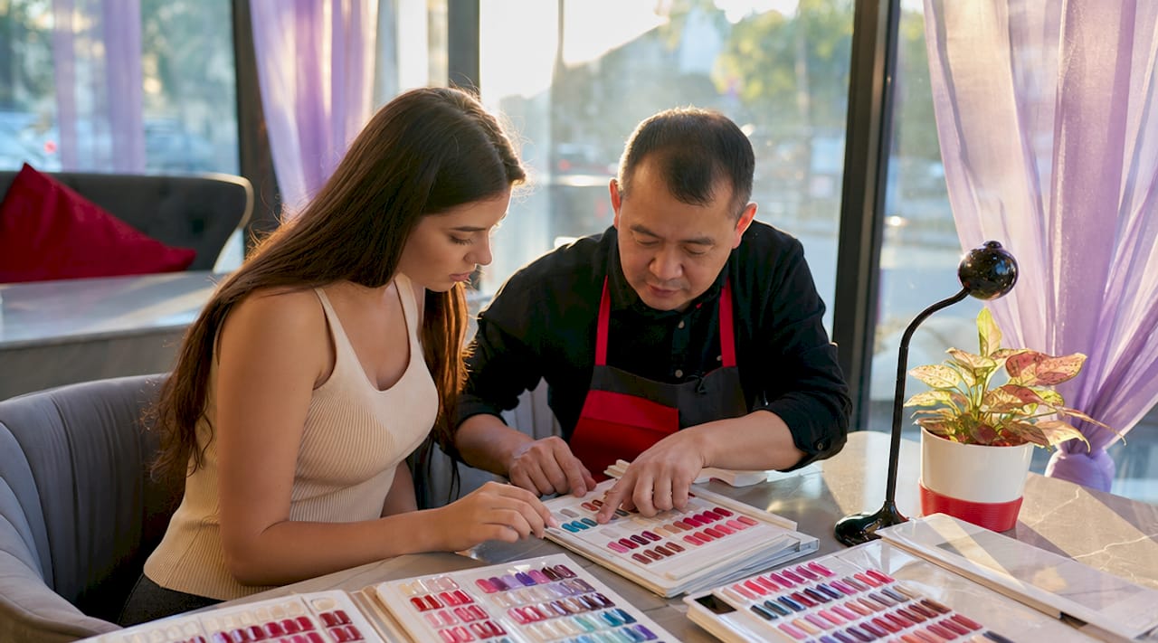 Client consulting nail technician on manicure style