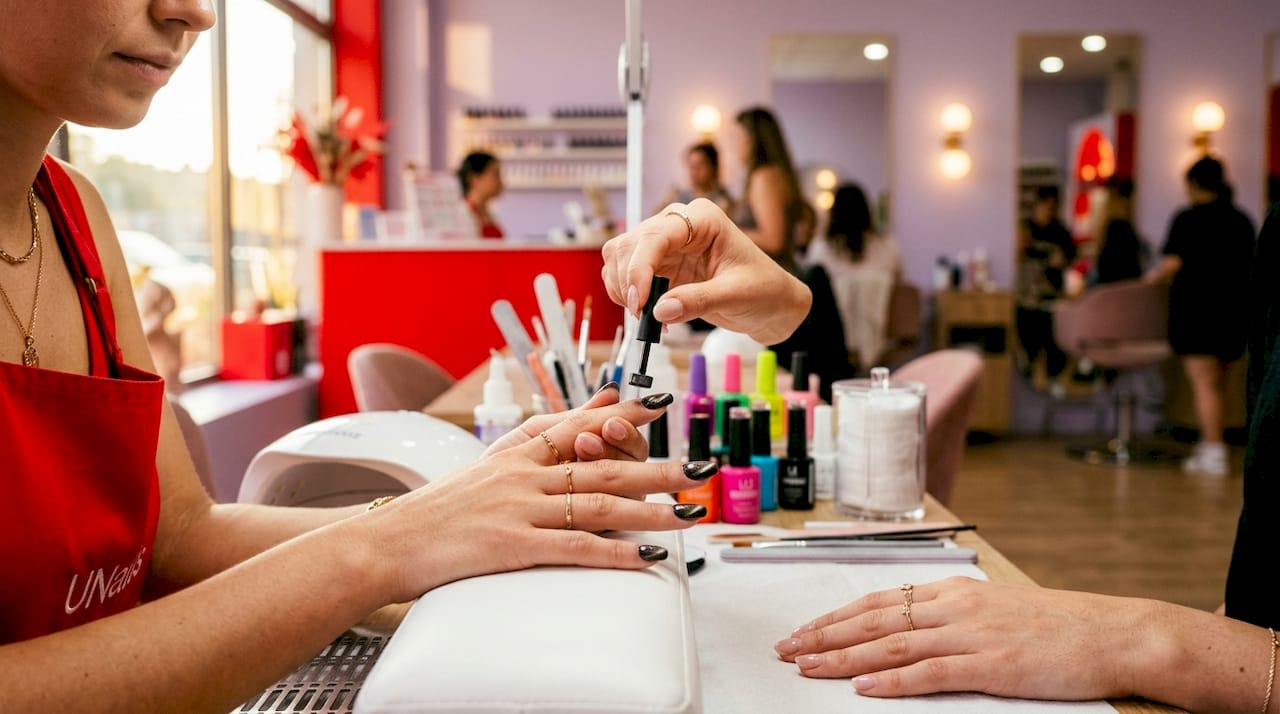 Hand applying magnetic cat-eye gel nails professionally