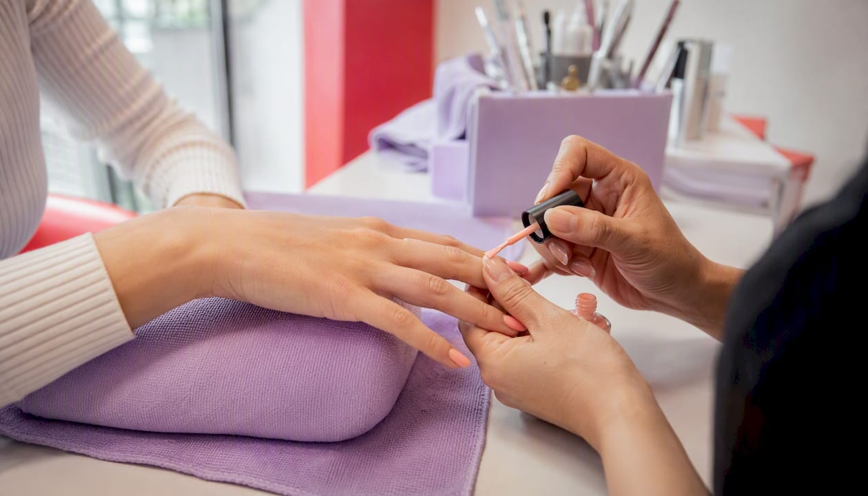 Technician applying pastel spring nail polish