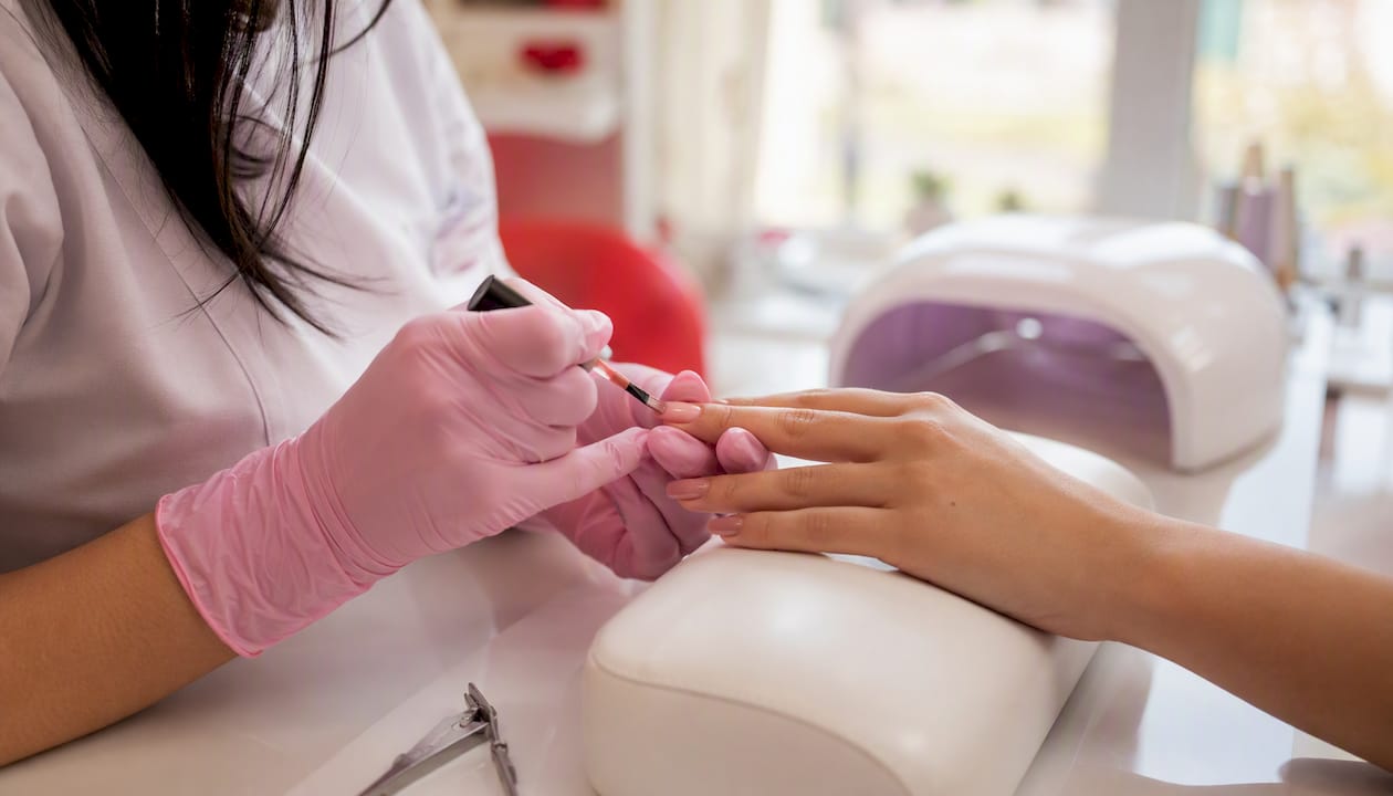 Nail technician applying gel polish on nails