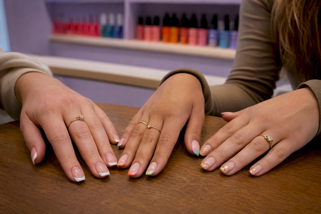 Three hands showing varied French manicure styles