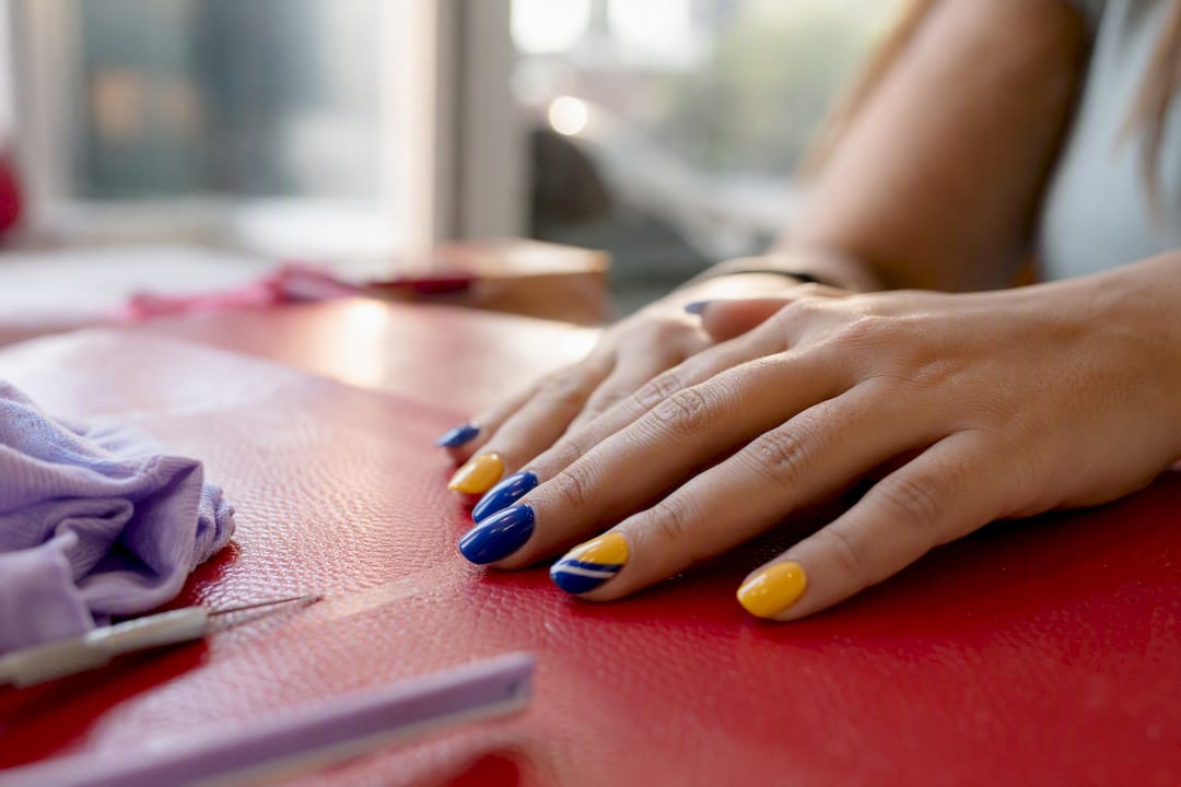 Hand with bold colorful glossy nail art