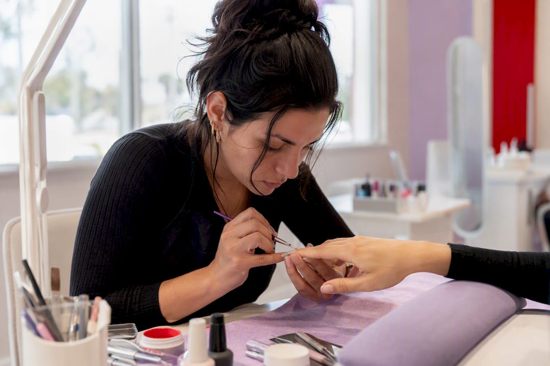 Technician applying builder gel on natural nail