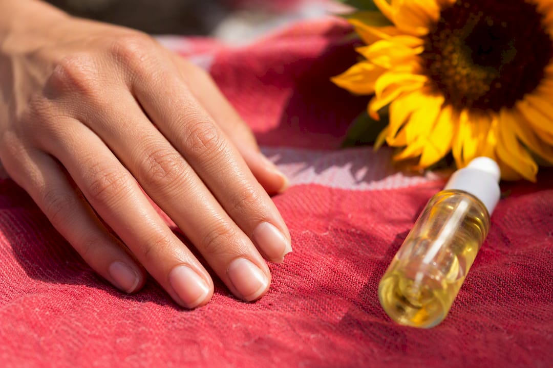 Close-up of hand with broken fingernail and nail care tools