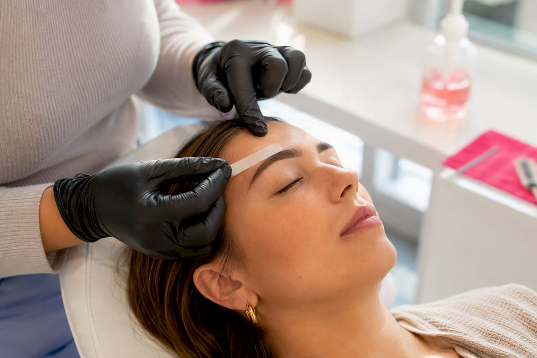 Close-up of eyebrow waxing in action