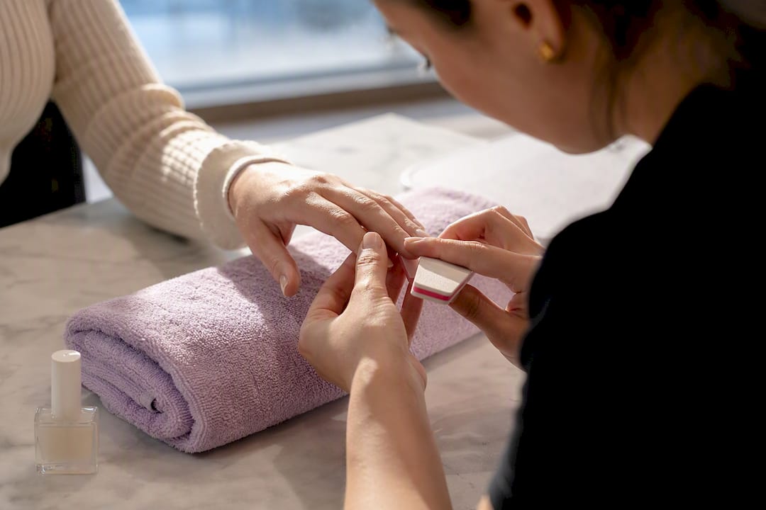 Technician preparing nails for nude manicure