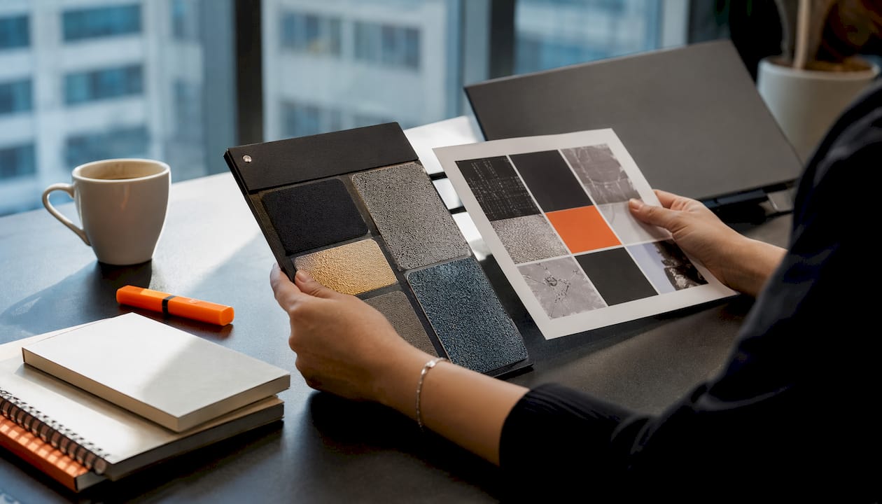 Close-up of hands evaluating printed sample swatches