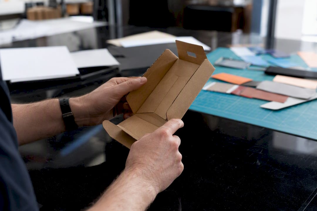 Hands inspecting physical packaging prototype