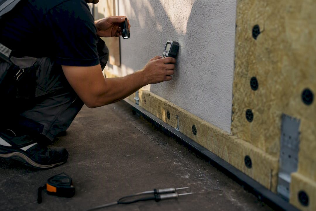 Hands inspecting wall substrate detail