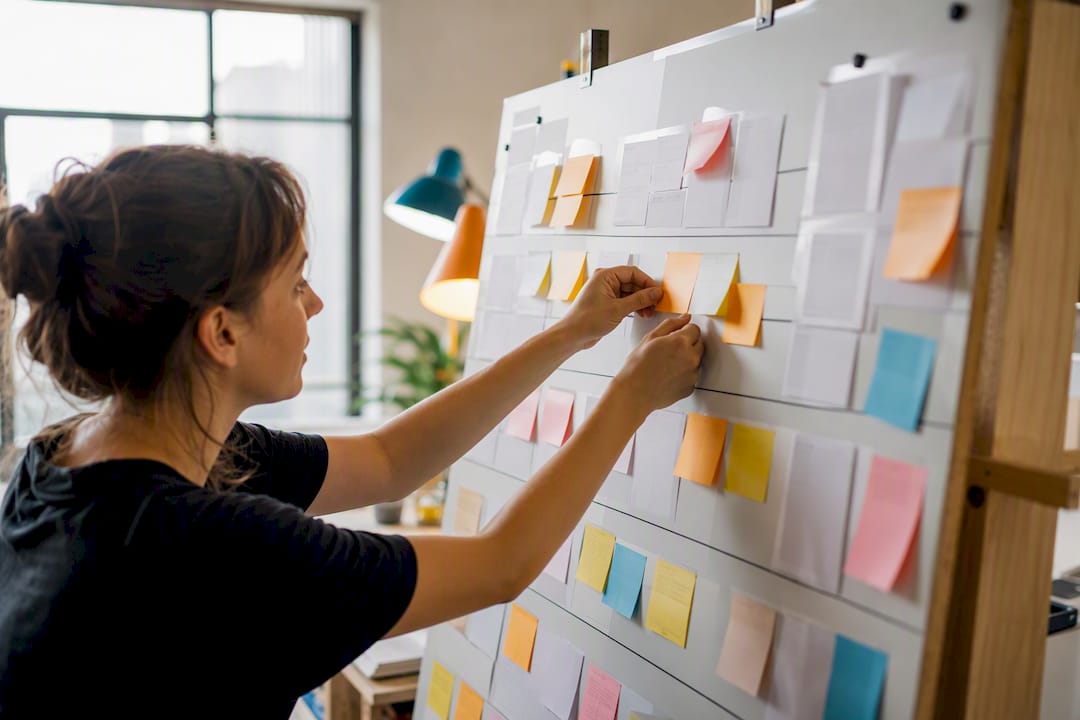 Hands managing print order tracking board