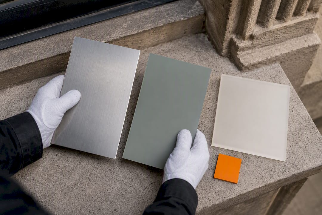 Hands comparing muted heritage signage finishes