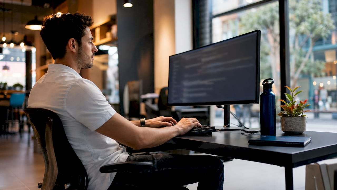 Developer coding responsive website at desk