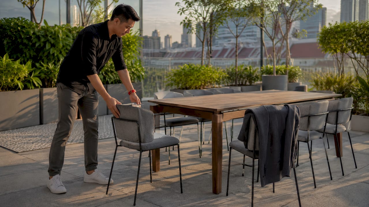 Hands arranging event chairs in conference room