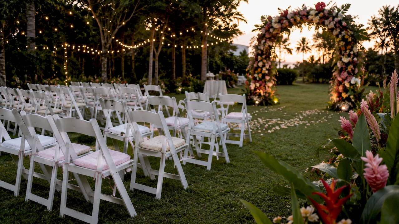 Wooden wedding chairs arranged outdoors in Singapore garden