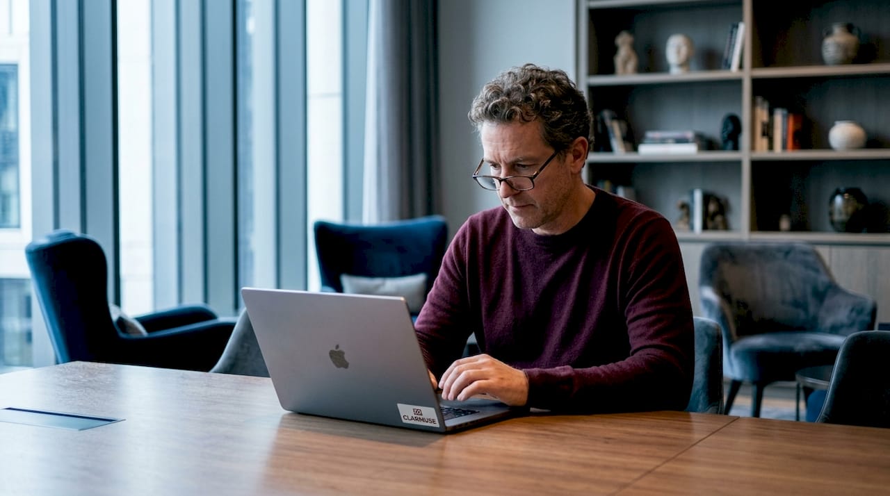 Hombre usando MacBook con pantalla de privacidad en la biblioteca