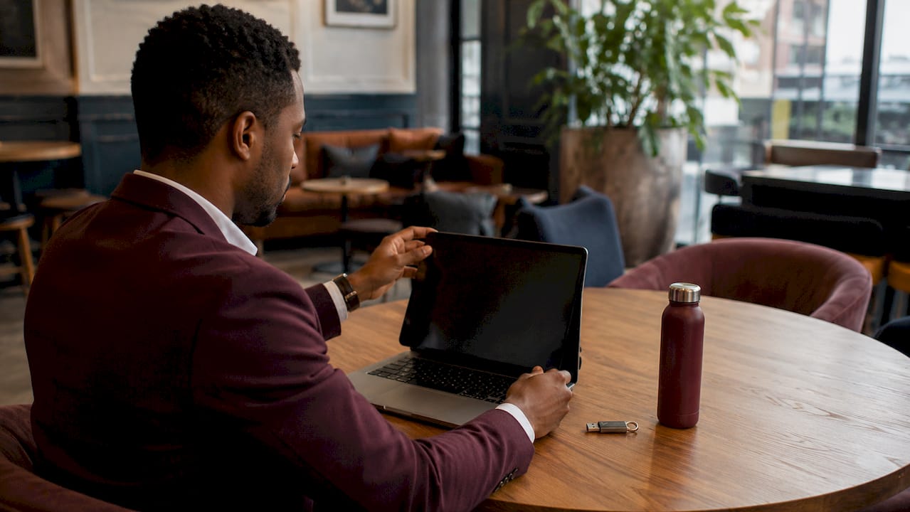 Hands typing on laptop with privacy filter in co-working