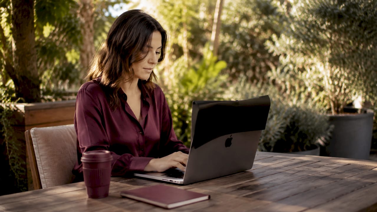 MacBook keyboard and hand adjusting security settings