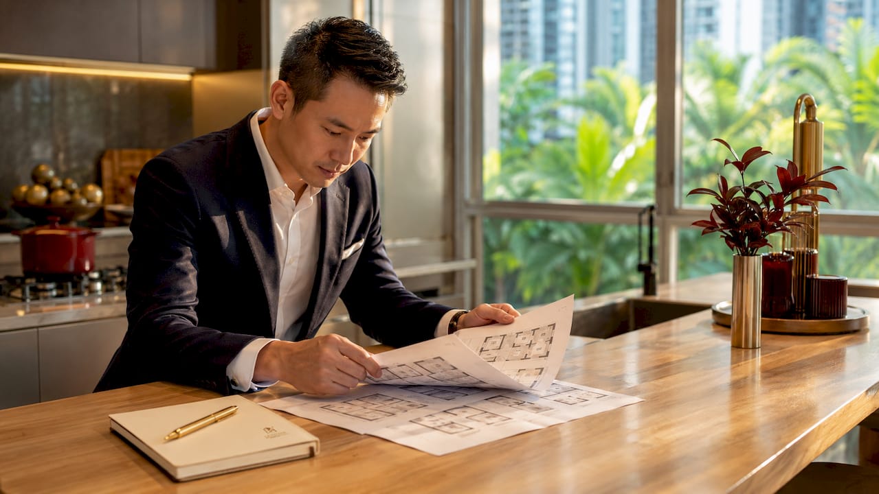 Man reviewing HDB flat layout plans indoors