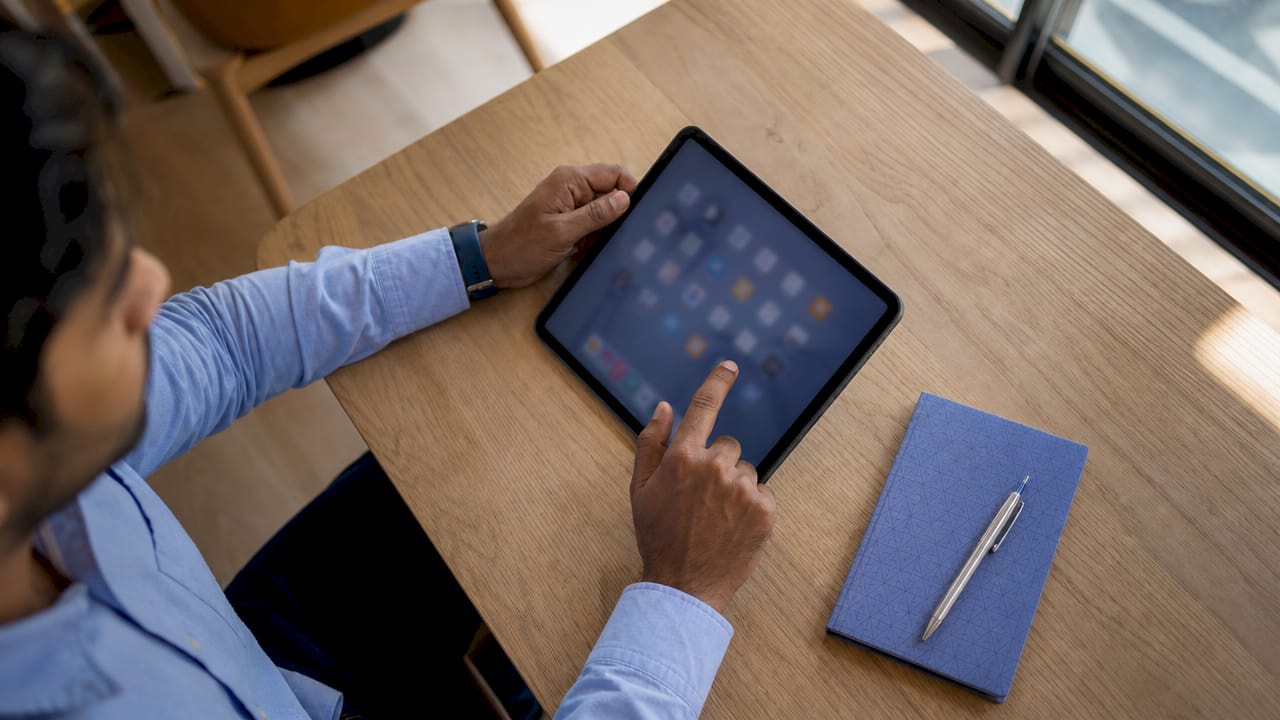 Une personne passe en revue les critères de sélection d’outils pour freelances sur sa tablette.