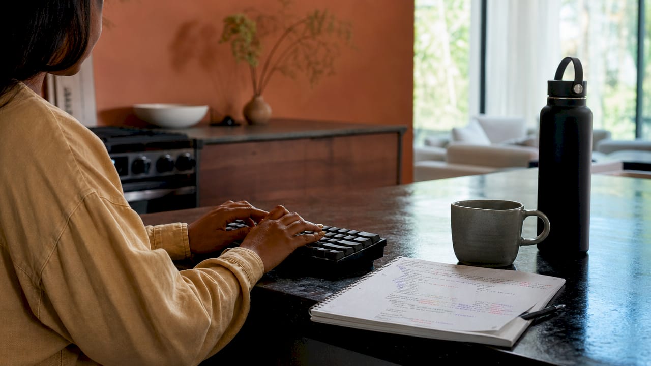 Hands typing schema code with notes