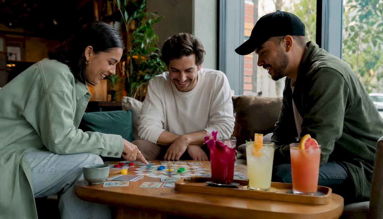 Colleagues playing game with alcohol-free cocktails nearby