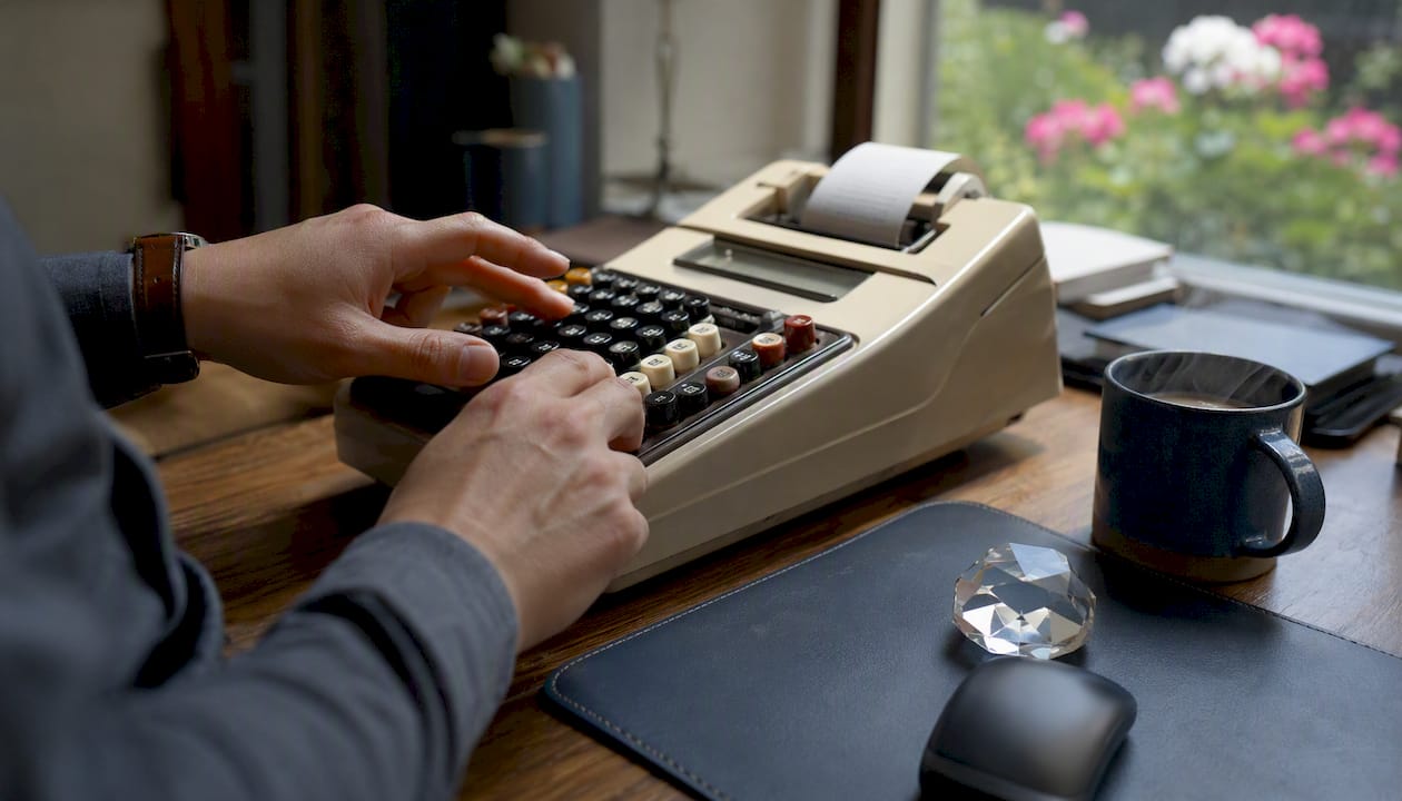 Hands operating adding machine on desk