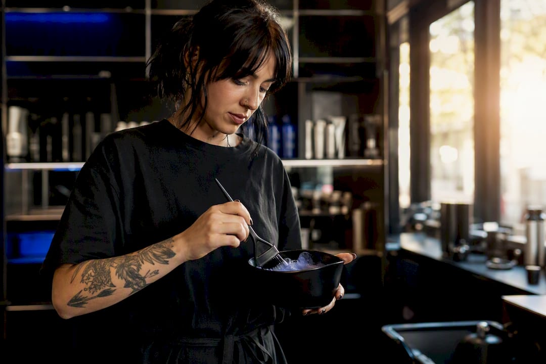 Stylist mixing hair color in salon bowl