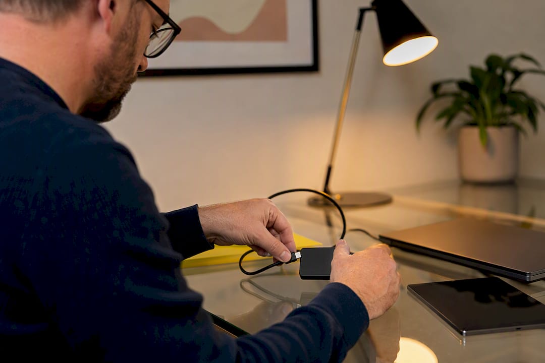 Hands connecting tech devices for data hygiene