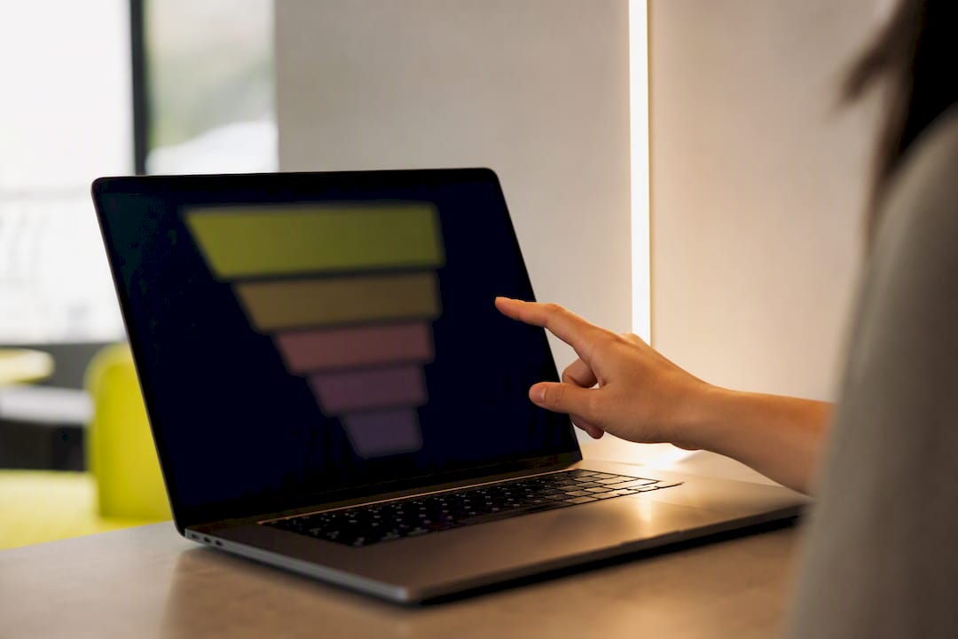 Hand pointing at blurred sales funnel chart on screen